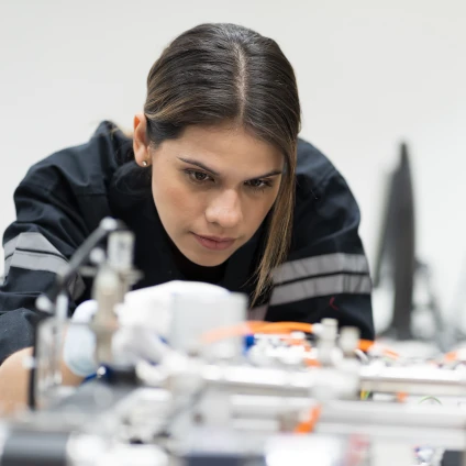 Female engineer training AI robot training kit and mechatronics engineering in the manufacturing automation and robotics academy room